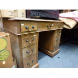 A small early 20th century pedestal desk of nine drawers beneath a green fabric covered top. WE DO