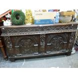 A substantial 18th century and earlier oak coffer the panelled front carved with fruit flanking