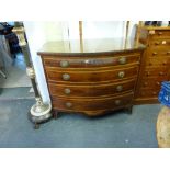 A George III bow-fronted chest of four graduated drawers each cross-banded in satinwood above a
