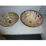 Two early Persian pottery bowls, each with cream ground, one painted with probably stylised script