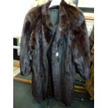 A dark brown mink fur lady's full length coat with swing back, wide cuffs and concealed front