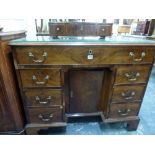 A George III mahogany knee-hole desk, the top drawer with hinged front above a small cupboard