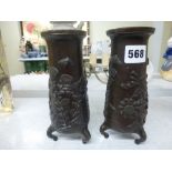 A pair of Japanese bronze vases, Meiji period, cast with flowers, on three feet, signed, 18 cm [R]