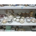 A shelf of porcelain, mainly English, early 19th century, including various tea bowls and saucers,