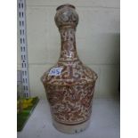 A Persian Kashan pottery bottle vase painted with flowers in brown on a cream ground and with