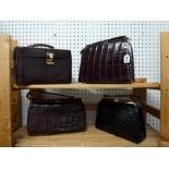 Three 1950s alligator skin handbags, two brown and one black, and a skin vanity case containing