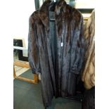 A lady's full length dark brown mink fur coat with gathered cuffs, concealed front fastening and