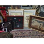 A selection of various framed items, including decorative prints, a mirror, a framed cowboy shirt,