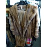 A lady's brown mink fur short jacket with wide shawl collar and a long pastel mink fur wrap [rail in