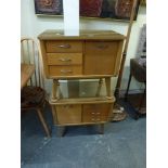 A pair of 1950s bedside cabinets each with three drawers, and a small cupboard on splayed legs. WE