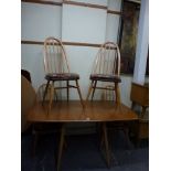 An Ercol drop-flap dining table in light beech and four matching stick-back chairs. WE DO NOT TAKE