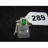 A modern pretty rectangular emerald and diamond cluster ring in 18 ct white gold WE DO NOT TAKE