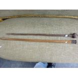 Two walking canes one with double headed handle the second military and Malacca with the