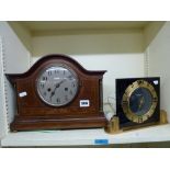 A wooden cased mantel clock with inlaid bow and line decoration with two brass column supports and a
