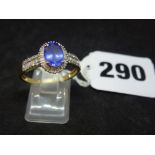 An elegant modern tanzanite and diamond cluster ring with diamond shoulders, in 9 ct yellow gold