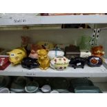 Three shelves of mixed items including novelty piggy banks including two by NatWest Piggies,