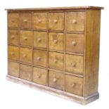 An early to mid 20th century pine drawer unit, with an arrangement of twenty drawers, turned