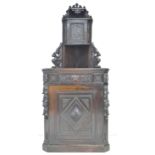 An oak freestanding corner cupboard, mid to early 20th century, carved in Dutch style with lion?s