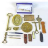 A group of brass items, including a couple of ash trays, three bottle openers and a letter opener,