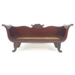 An early 19th century hall seat, narrow form settee, with scroll arms, carved decoration, and