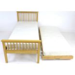 A modern wooden single bed, with an additional pull out bed with sprung folding legs, slides and