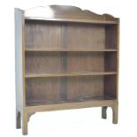 An Edwardian mahogany bookcase, with shaped top, two adjustable shelves and two fixed shelves, 99 by