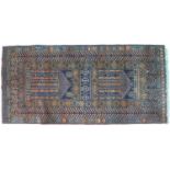 A Persian wool prayer rug, the dark blue ground decorated with geometric designs in oranges and