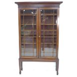 An Edwardian mahogany display cabinet, twin astragal glazed doors enclosing four adjustable shelves,