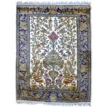 A Kirman Tree of Life rug, cream ground, dark blue border, decorated with oranges, greens, reds, and