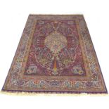 A Persian rug with dark blue ground, profusely patterned red and multicoloured floral and