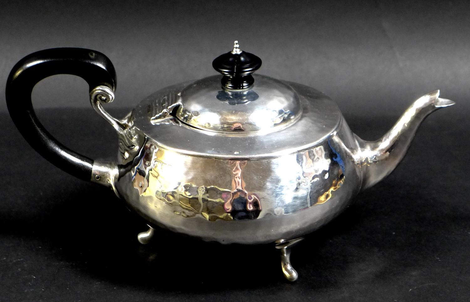 An Arts & Crafts silver teapot, of compressed ovoid form, with all over hammered finish, ebonised - Image 4 of 9