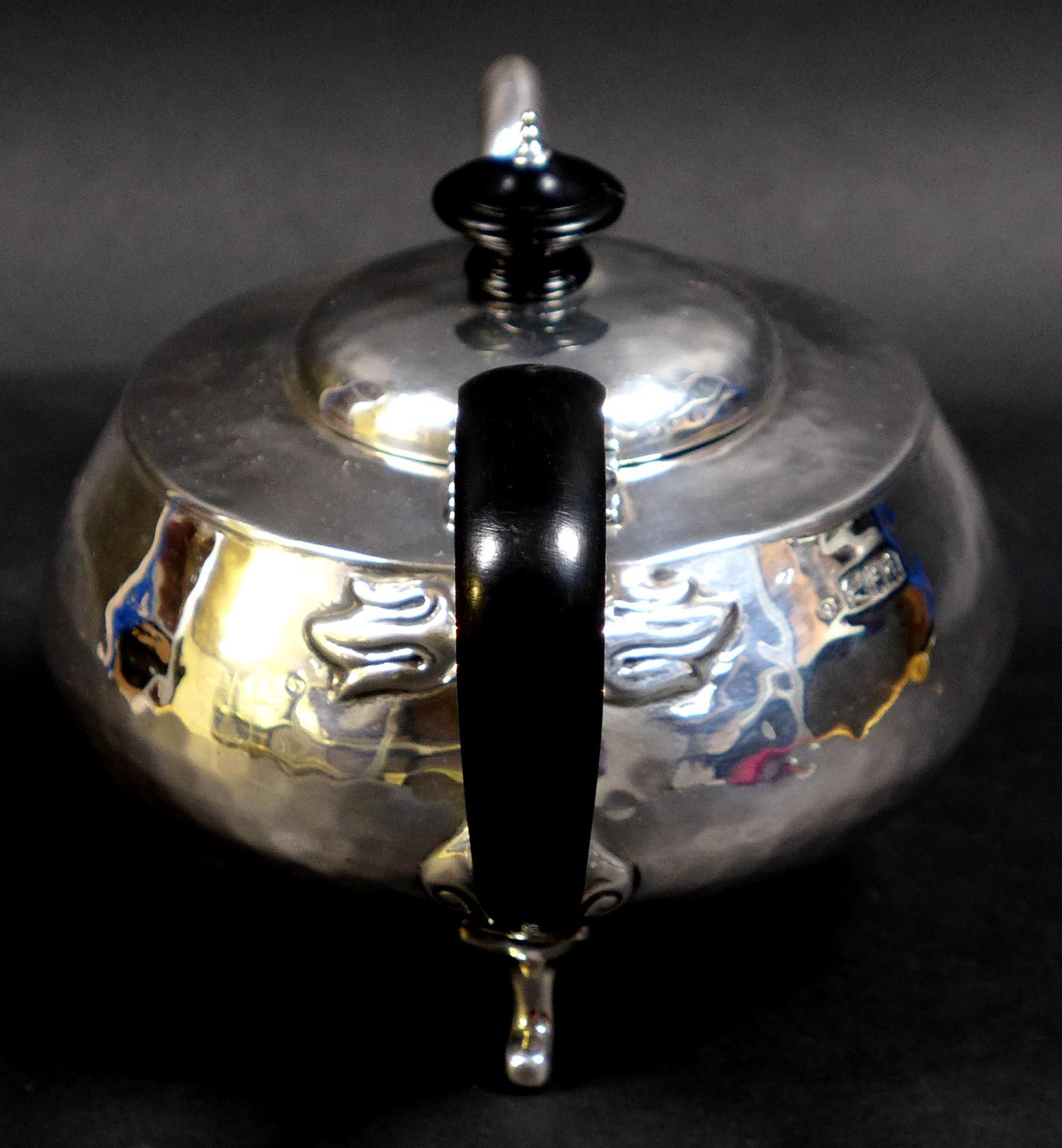 An Arts & Crafts silver teapot, of compressed ovoid form, with all over hammered finish, ebonised - Image 3 of 9