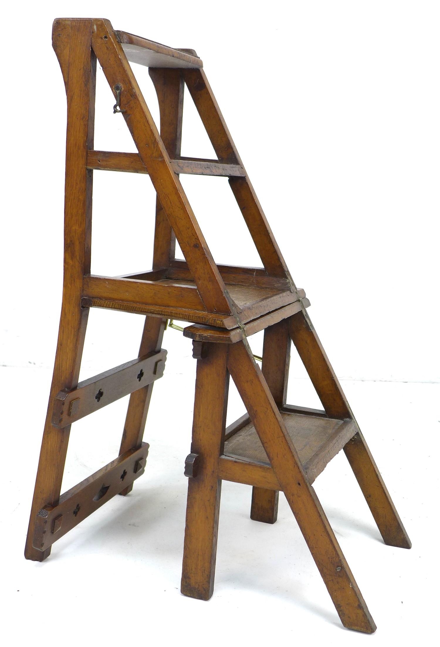 A set of oak metamorphic library steps, folding into a chair, the top rail with pierced quatrefoil - Image 2 of 10