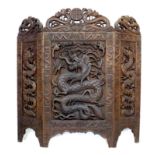 A Chinese three panel carved wooden screen, mid 20th century, intricately carved with dragons,