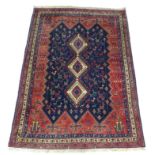 A Sirjan rug with dark blue ground, the zigzag outline field centred by three conjoined cream