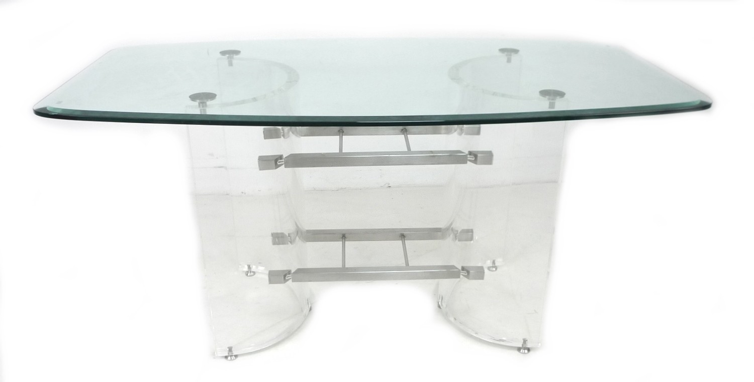 A modern design dining table, shaped rectangular clear glass surface with bevelled edge raised on