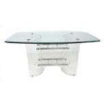 A modern design dining table, shaped rectangular clear glass surface with bevelled edge raised on