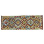 A vegetable dyed wool Choli Kelim runner, with six large diamond medallions to the field and
