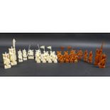 A Chinese ivory chess set, circa 1930, natural and stained pieces individually carved depicting