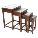 A Chinese hardwood nest of four tables, carved decoration, glass tops, largest 51 by 35 by 64cm