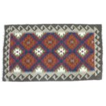 A Maimana Kelim rug, the central field having repeating diamond motif in red, green orange and