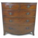 A Regency mahogany bow front chest of two over three graduated drawers, with cock beading and oval