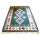 A Choli Kilim rug, with green ground, pink, cream and blue decoration of three diamonds and four