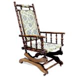 An American rocking chair, wooden turned spindle frame, metal sprung rocking action, floral