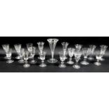 A collection of clear glass drinking glasses, mostly Victorian and later, including trumpet shaped
