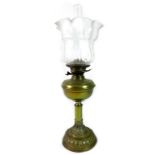 A Victorian brass paraffin lamp, with brass reservoir above column, on a circular base, with clear