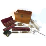 A doctor's brown leather Gladstone bag, containing various vintage pieces of medical equipment.