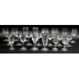A collection of clear glass drinking glasses, mostly Victorian and later liqueur glasses,