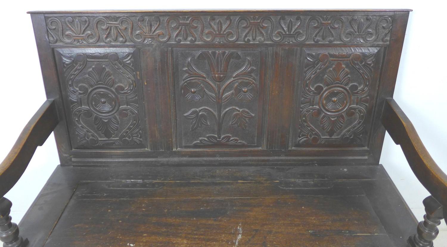 An 18th century oak settle, with carved frieze above a three panel carved back, open shaped - Image 4 of 8