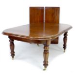 A 20th century Victorian reproduction mahogany extending dining table, turned legs and brass